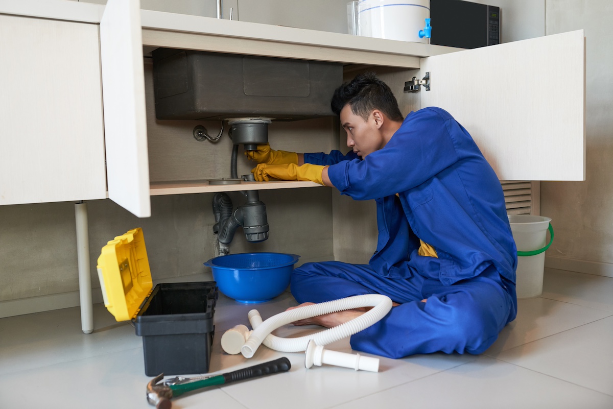 Plumber applying sealant